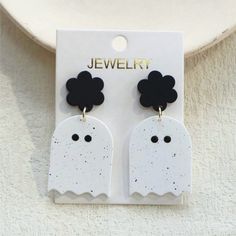 a pair of black and white ghost earrings