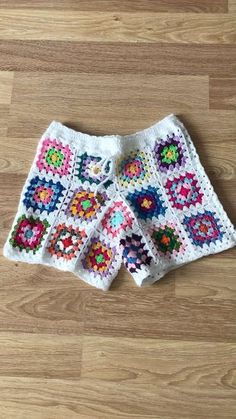 a crocheted shorts is laying on the floor next to a wooden floor with wood floors