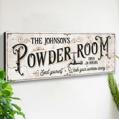 a sign that says the johnson's powder room hanging on a wall next to a potted plant