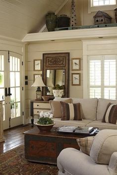 a living room filled with furniture and decor on top of a hard wood floored floor