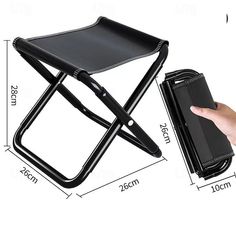 the folding chair has a tablet on it and is held up by a person's hand