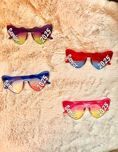 These sunglasses come in a four-pack and are fun to share with your friends or to keep all the colors to wear yourself. They are handmade and each four-pack comes with a pair of yellow/pink, red/blue, purple/green, and blue/pink heart-shaped sunglasses. I graduated in 2022 and I made myself a pair that I loved and made so many memories in, so I decided that I should share the fun! They would be great to wear in senior pictures! **On your order, please specify if you would like 2025 or a different year on the sunglasses. If you do not specify, it will be assumed you would like 2025 written on them.** Trendy Rainbow Sunglasses With Gradient Lenses, Rainbow Sunglasses With Uv Protection For Summer, Fun Multicolor Sunglasses With Gradient Lenses, Fun Multicolor Tinted Sunglasses, Fun Multicolor Sunglasses With Uva Protection, Senior Sunglasses, Senior Year Things, Senior Szn, I Graduated