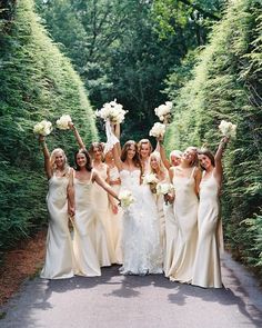 a group of bridesmaids holding their bouquets in the air