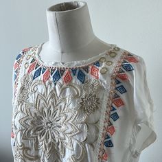 Nwt Beautiful Johnny Was Embroidered Cap Sleeve Top. Ivory (Jw Color States “Natural”) Background With Multi Colored Embroidered Florals And Geometric Designs. Please See Close Up Pictures For All The Fabulous Details With Metallic And Soft Playful Colors. This Top Has Small Pockets In The Front (Also Pictured Close Up) And A Raw Edge Cool Neck Detail. Easy To Dress Up Or Down!! This Is A Forever Classic Piece With Its Incredible Detailing!! Summer White Tops With Intricate Embroidery, Beige Embroidered Bohemian Top, White Tops With Intricate Embroidery For Summer, Beige Bohemian Embroidered Top, Traditional Cream Embroidered Summer Top, Embroidered Cream Top For Festival, Embroidered Cream Tops For Festival, Summer Multicolor Embroidered Fabric, Traditional Cream Embroidered Top For Summer