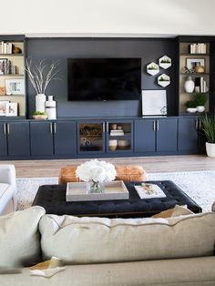 a living room filled with furniture and a flat screen tv mounted on a wall above a fireplace