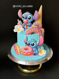 there is a blue cake decorated with cartoon characters