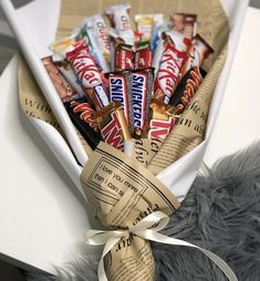 a candy bar wrapped in brown paper and tied with a white ribbon on top of a gray furnishing