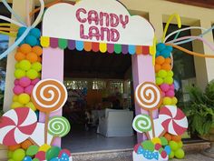 a candy land entrance decorated with balloons and streamers