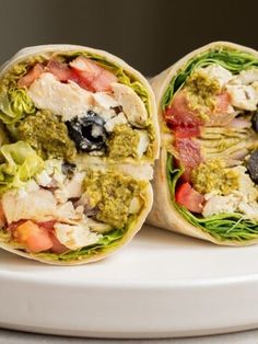 two burritos filled with meat and veggies on top of a white plate