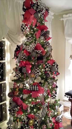 a christmas tree decorated with red, black and white bows