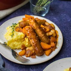 sausage and mashed potatoes on a white plate with a fork next to the plate