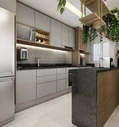 a modern kitchen with marble counter tops and stainless steel appliances, along with potted plants