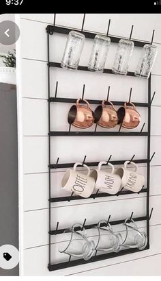 a wall mounted rack with cups and mugs on it