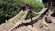 a toy truck driving over a wooden bridge made out of sticks and wood planks