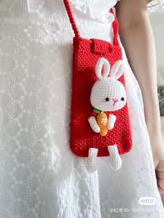 a crocheted rabbit bag hanging from a woman's back with an orange carrot in it