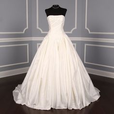 a white wedding dress on display in a room