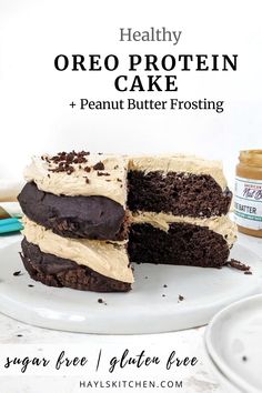 two pieces of chocolate cake with white frosting on a plate next to a jar of peanut butter