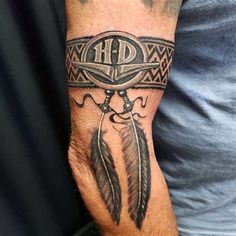 a man's arm with a tattoo on it and a feather in the middle