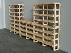 two wooden shelving units sitting next to each other on a tile floor in front of a gray wall