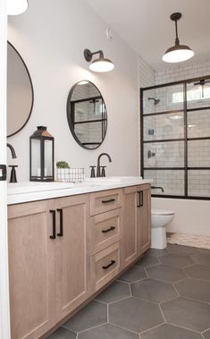 a bathroom with two sinks and three mirrors