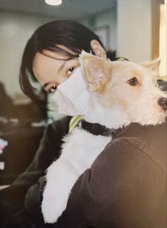 a woman holding a dog in her arms with a bandage on it's face