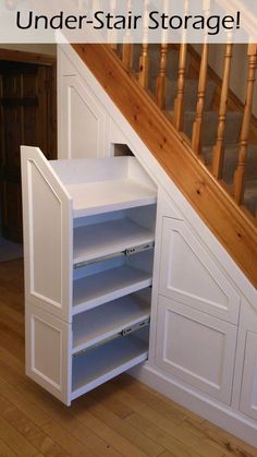 an under the stairs storage unit in a house with hardwood floors and wooden bannisters