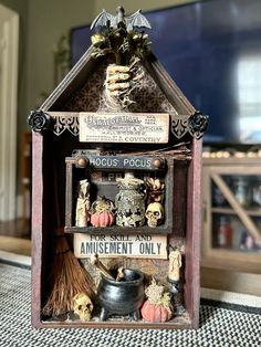 a doll house with lots of decorations on the front and back sides, including a skeleton holding a broom