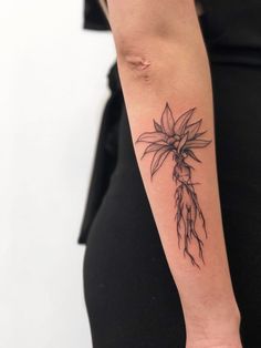 a woman's arm with a flower tattoo on it