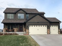 a large house with two garages in front of it