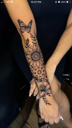 a woman's arm with sunflowers and butterflies tattooed on the left forearm