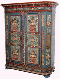 an ornate painted armoire with drawers