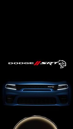 the front end of a blue dodge car with an emblem on it's side