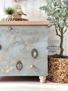 an old dresser with knobs on it next to a potted plant