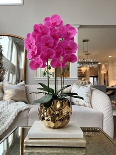 a living room filled with furniture and a large flower pot on top of a table