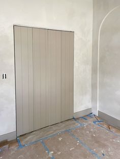 an empty room with two white doors and some blue tape on the floor in front of it