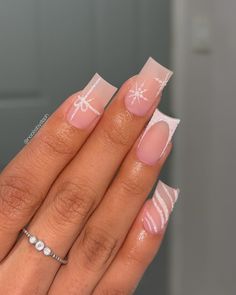 These medium square nails showcase a matte nude base adorned with subtle sparkle details and white snowflake accents. Each nail has a unique design, from gift-wrapped art to soft stripes, adding a fun, winter vibe. Perfect for a playful yet refined winter manicure. French Tip And Snowflake Nails, Gift Wrap Nails, Christmas Nails White Snowflake, Subtle Christmas Nails Square, Neutral Christmas Nails Square, Winter Nails Design Ideas 2024, Snow Design Nails, Holiday Nails With Bows, Christmas Nails With French Tip