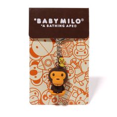 a keychain with a monkey on it in front of an orange and white background