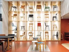 a room filled with lots of chairs and tables next to a book shelf full of books