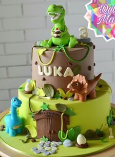 a dinosaur themed birthday cake on a table