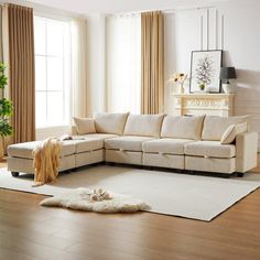 a living room filled with furniture and a rug on top of a hard wood floor