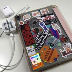 an electronic device with various stickers on it and earphones attached to the back