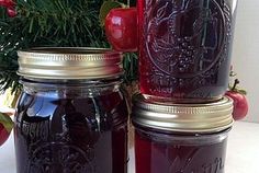 two jars filled with liquid sitting on top of a table next to an apple tree