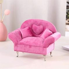 a pink chair with a heart shaped pillow on it