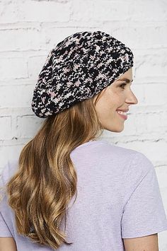 a woman with long hair wearing a black and white knitted beanie on her head