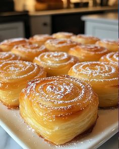 a white plate topped with lots of pastries on top of a counter next to an oven