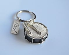 a close up of a small metal object on a keychain with a tag