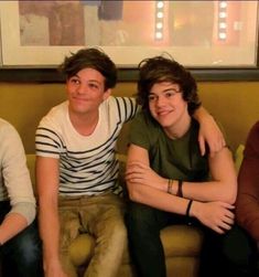 three boys sitting on a couch with their arms around each other