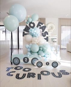 a birthday cake with balloons and letters on the floor