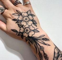 a woman's hand with a flower tattoo on it