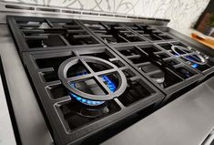 a gas stove with two burners and blue lights on the top, in a kitchen